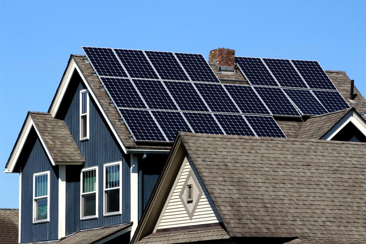 Solar panels covering the roof of a blue two-storey house